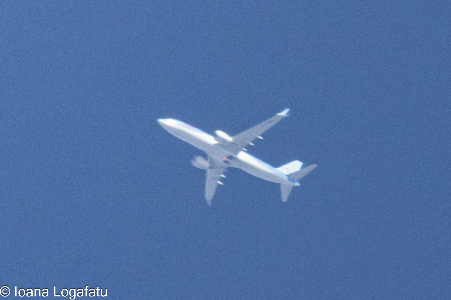 Airplane soaring through a bright blue sky
